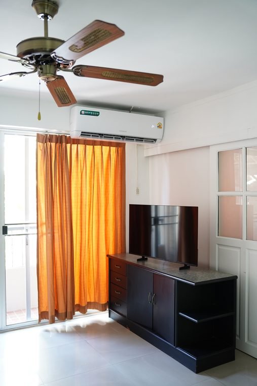 Suite living area with cabinet and ceiling fan