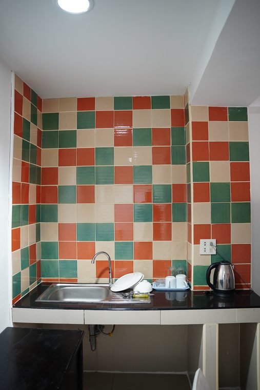 Suite sink and kettle area with tiled splashback