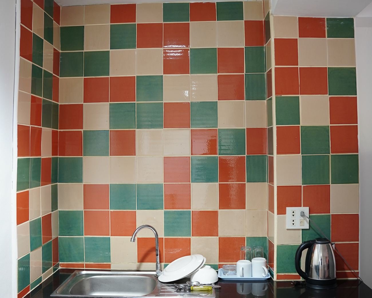 Suite sink and kettle area with tiled splashback